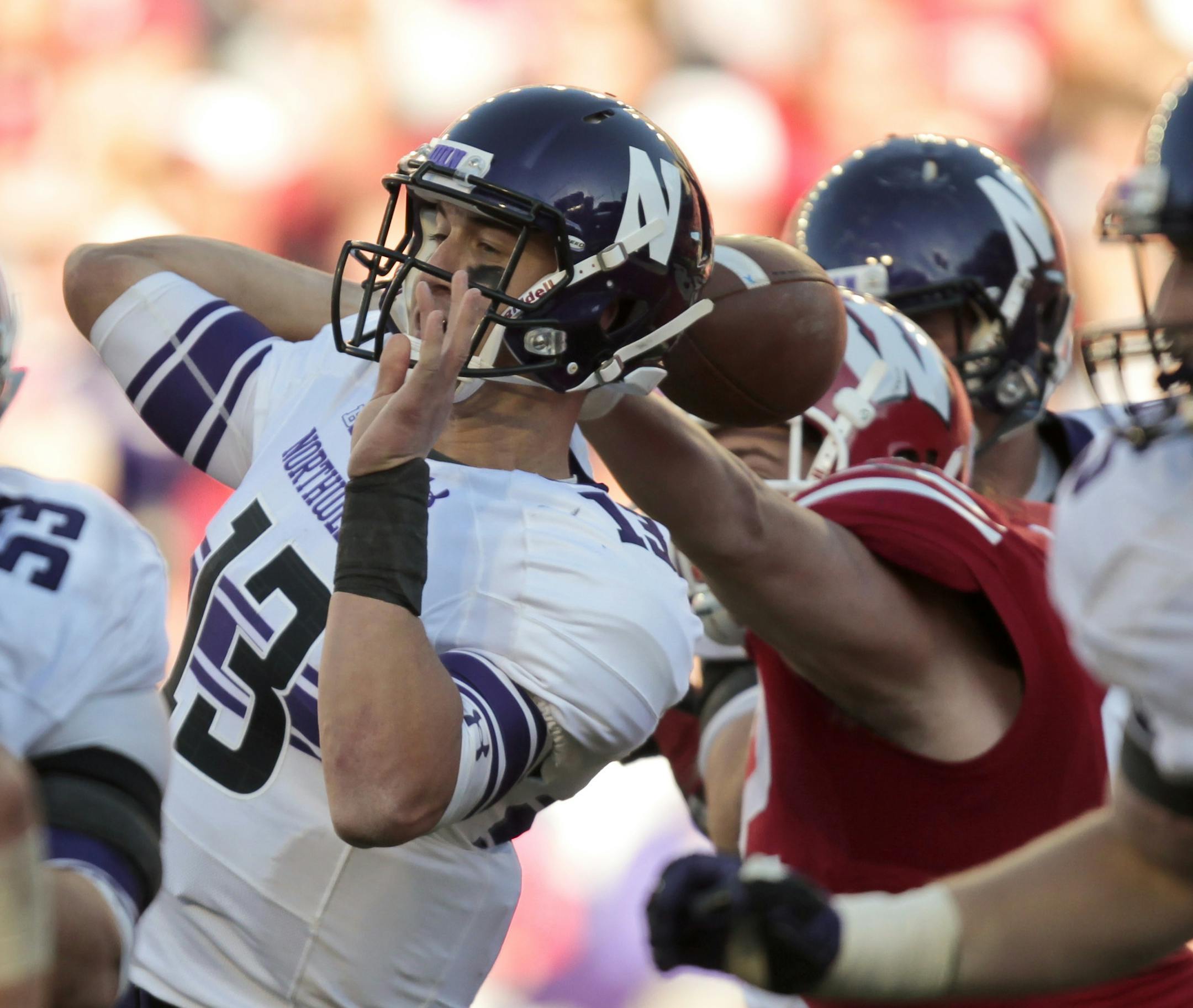 Wisconsin defensive end Pat Muldoon, right, forces a fumble on Northwestern quarterback Trevor Siemian during the second half of an NCAA college football game in Madison, Wis., Saturday, Oct. 12, 2013. Siemian recovered his own fumble. Wisconsin upset Northwestern 35-6. (AP Photo/Andy Manis)