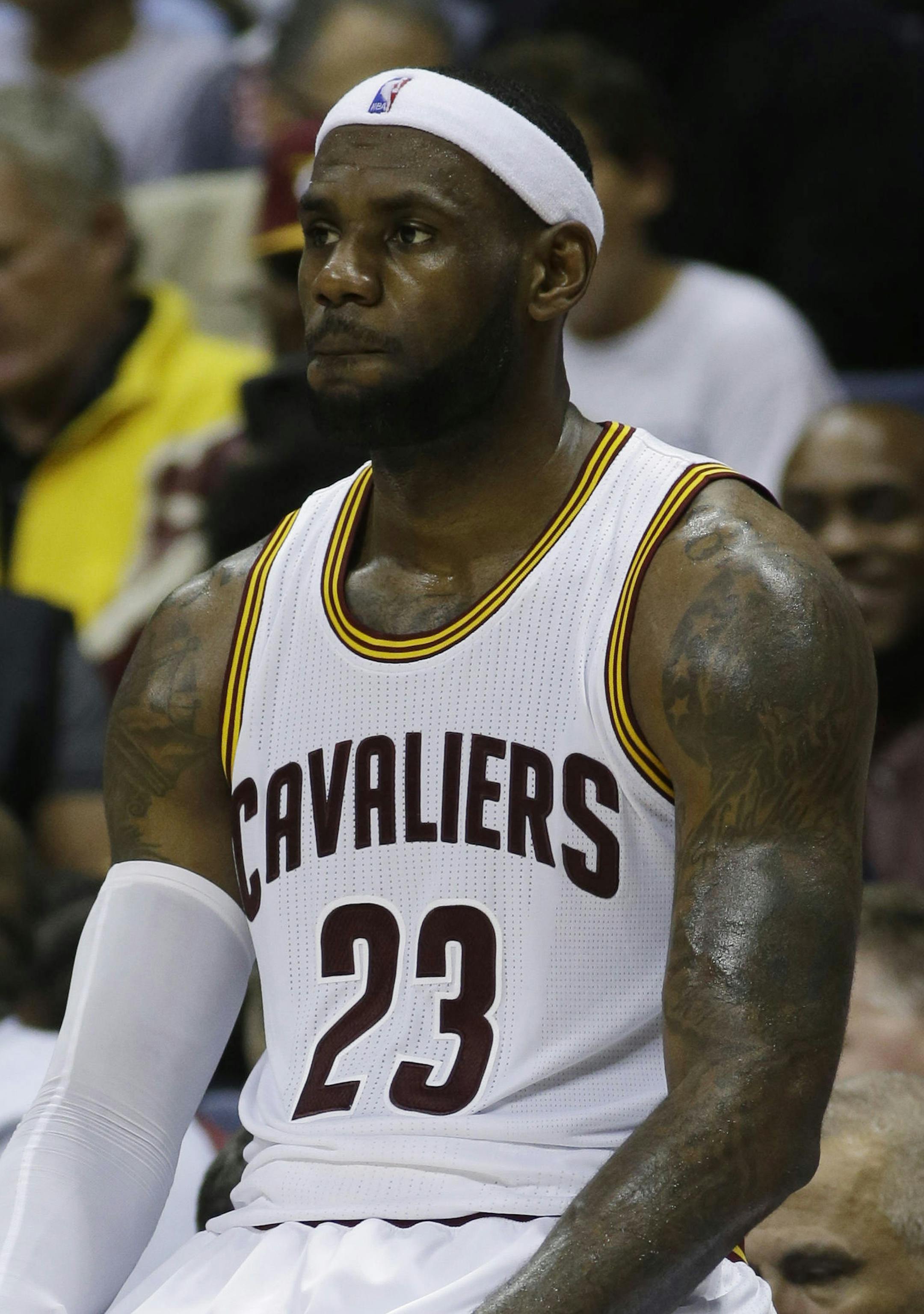 Cleveland Cavaliers forward LeBron James sits on the scorers bench during a timeout in the first half of an NBA preseason basketball game against the Indiana Pacers, Wednesday, Oct. 15, 2014, in Cincinnati. (AP Photo/Al Behrman)