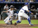 Minnesota Twins' Joe Mauer (7) beats a tag by Kansas City Royals catcher Salvador Perez to score on a single by Jake Cave during the fifth inning of a