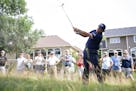 Phil Mickelson hits a ball out of the tall grass surrounded by spectators. ALEX KORMANN &#xa5; alex.kormann@startribune.com Competitors for the 3M Ope