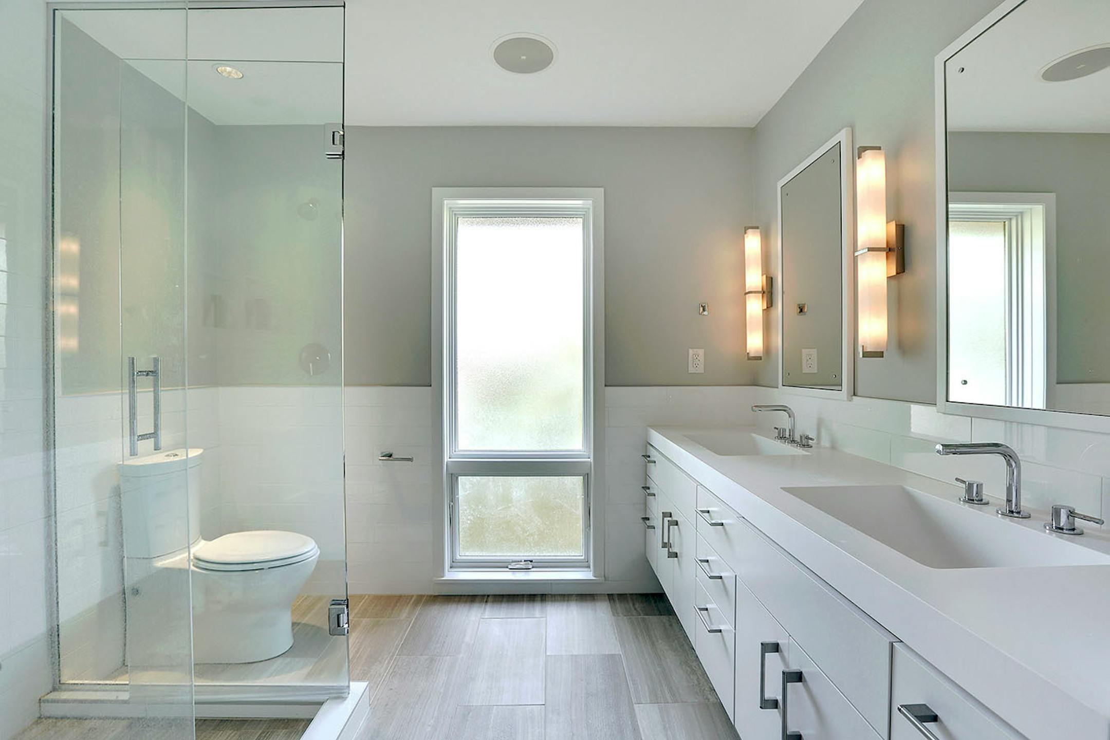 The simple and serene owner's bathroom features heated floors and double sinks.