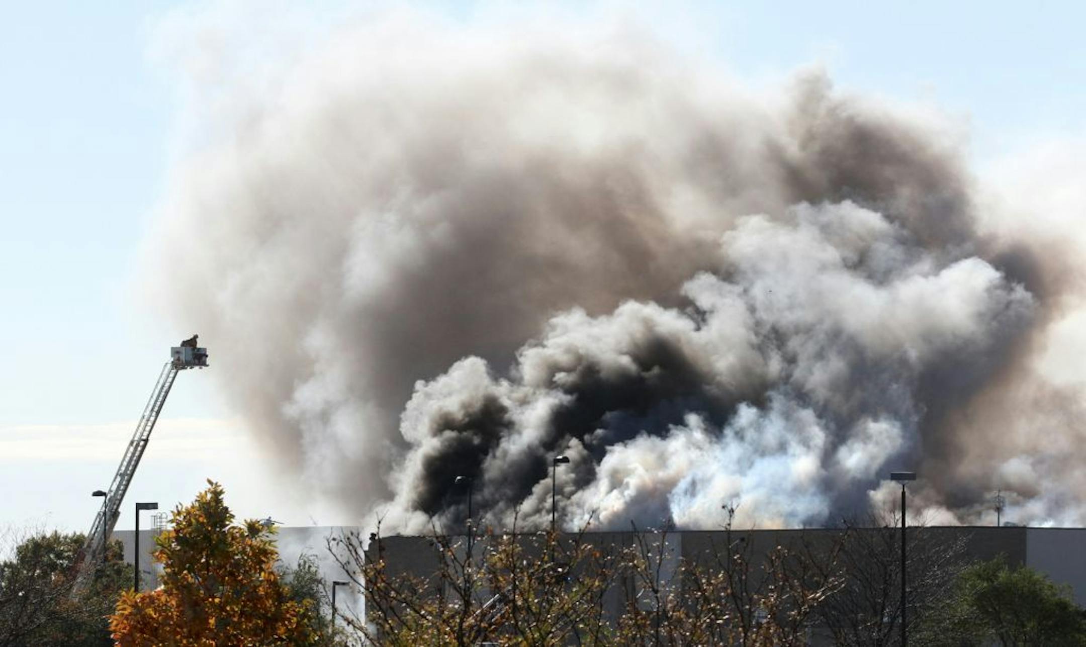 Smoke billows from a building at at Mid-Continent Airport in Wichita, Kan., Thursday, Oct. 30, 2014 shortly after a Beechcraft King Air B200 crashed into the building, killing several people, including the pilot.