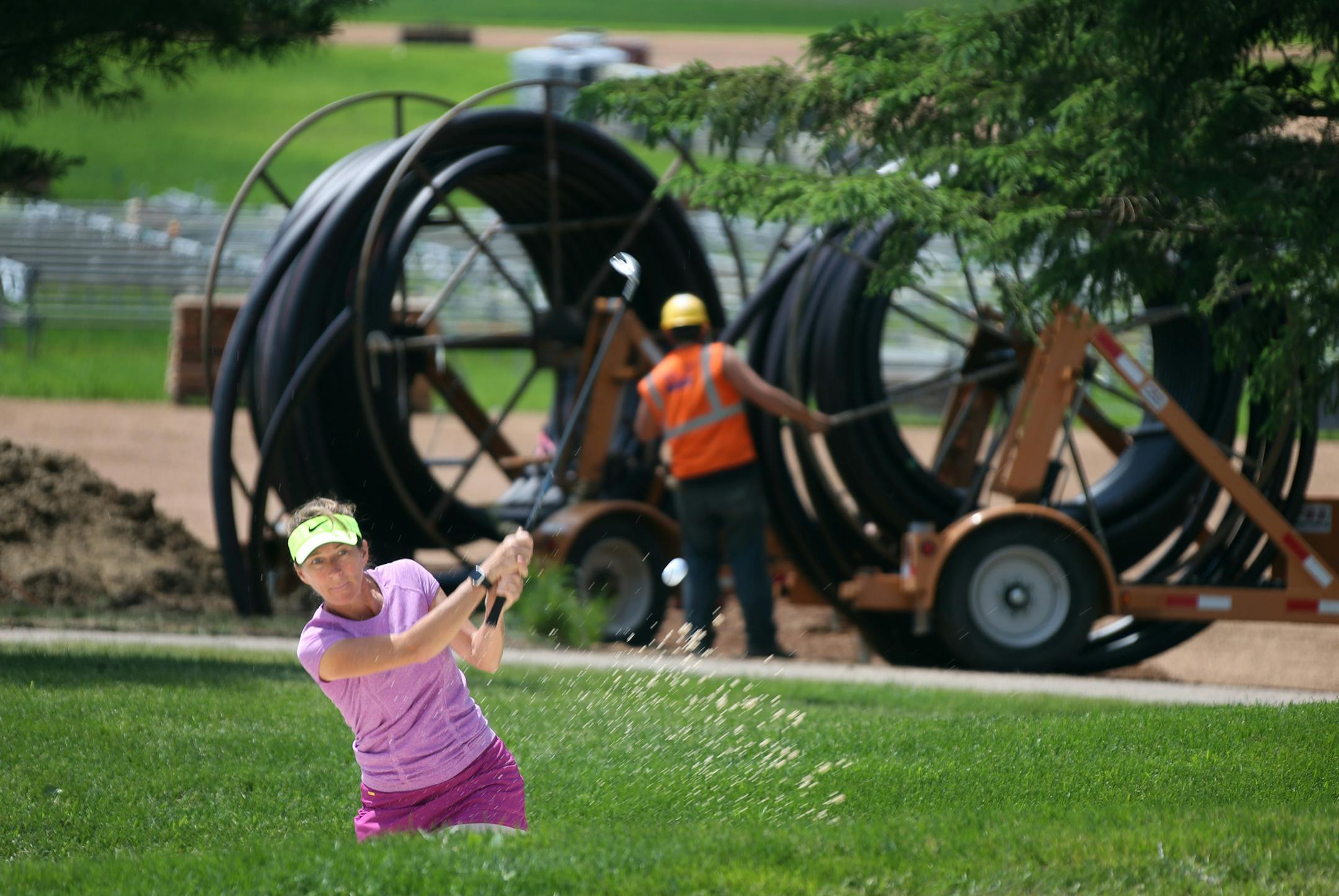 Chris Baisch teaching pro at Hazeltine watched as Lisa Ogren practiced hitting out of the sand trap near the construction site of the international pavilion Thursday June 9, 2016 in Chaska, MN.] Hazeltine is starting to ready itself to host the Ryder Cup later this summer. Jerry Holt /Jerry.Holt@Startribune.com