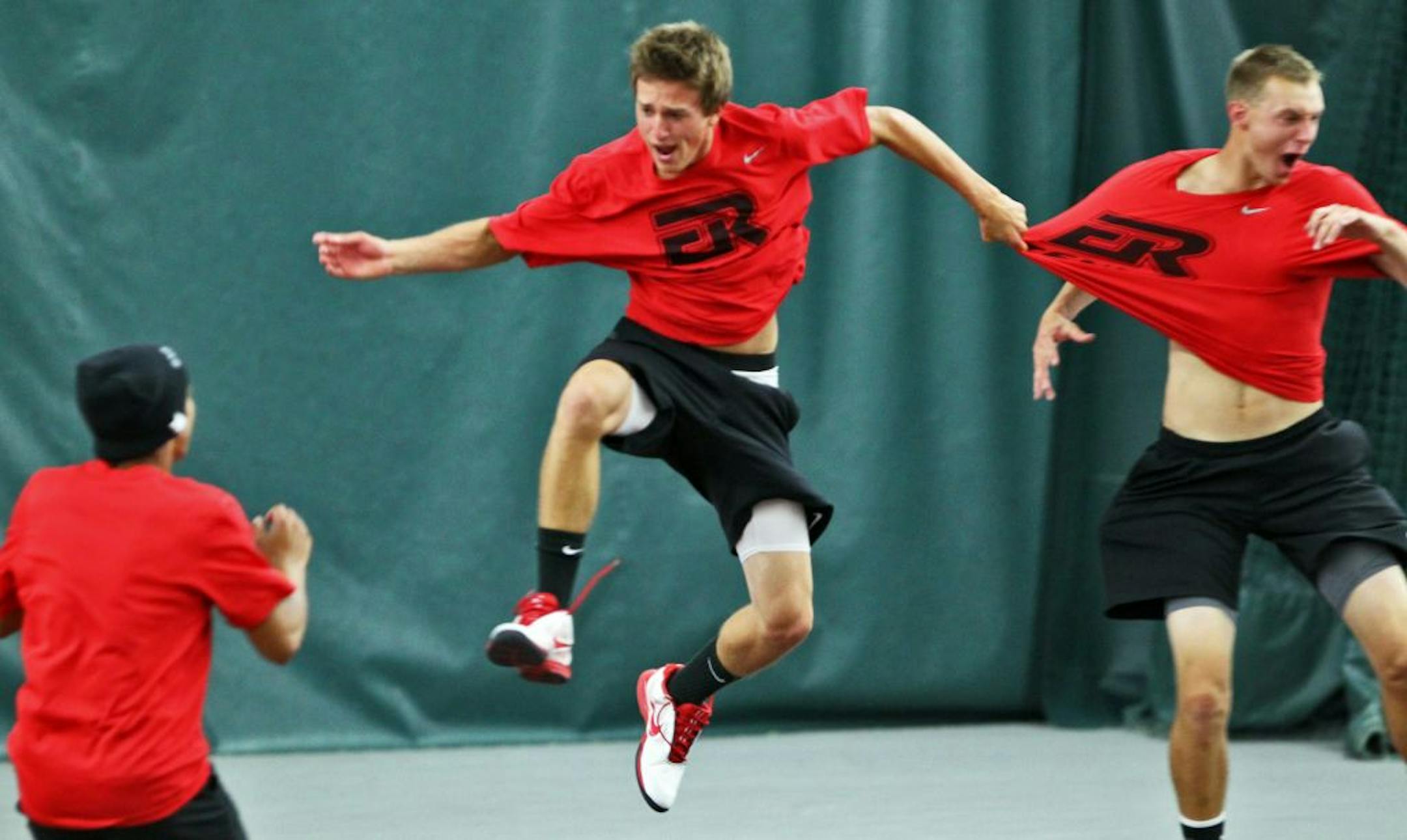 Elk River tennis players Steven Delain, center, and Mitch Brandell, right, whooped it up after clinching a 5-2 title victory over Wayzata.
