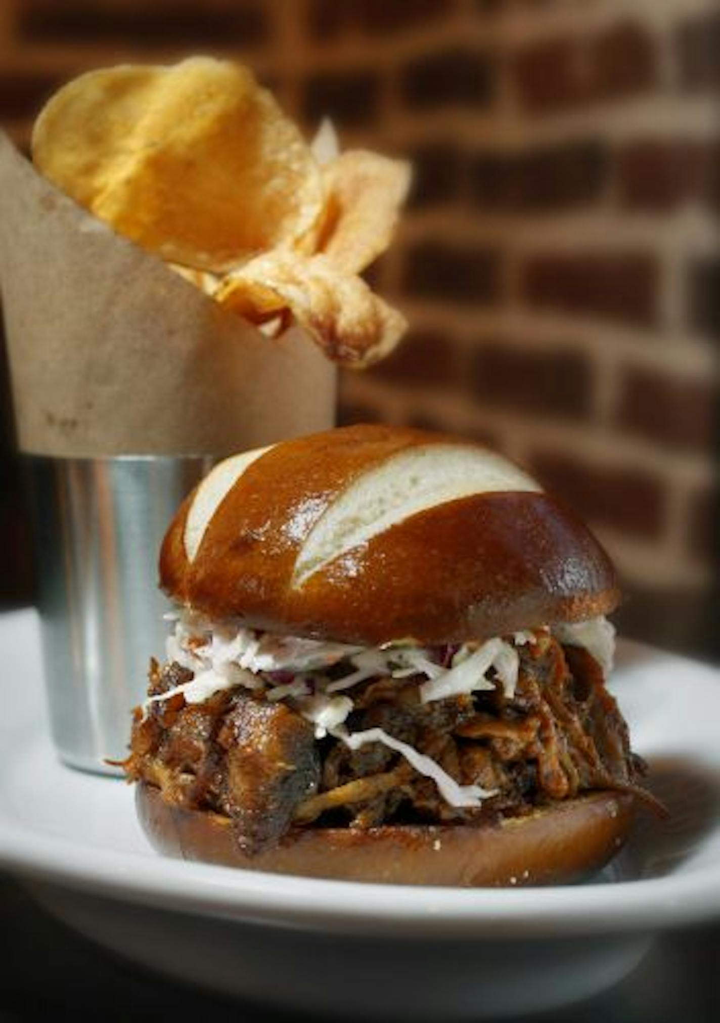 Pulled pork sandwich, served with a side of house-made potato chips.