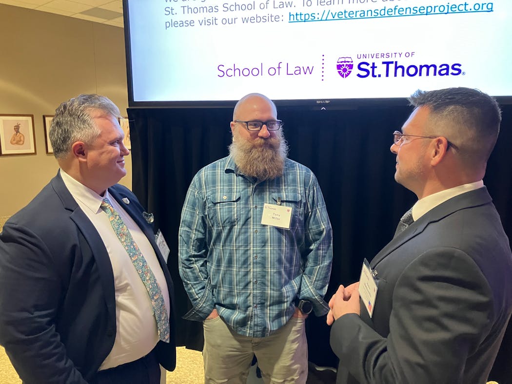 At a recent conference, Tony Miller, center, chatted with veterans Ryan Else, a lawyer, and psychologist Hector Matascastillo.
