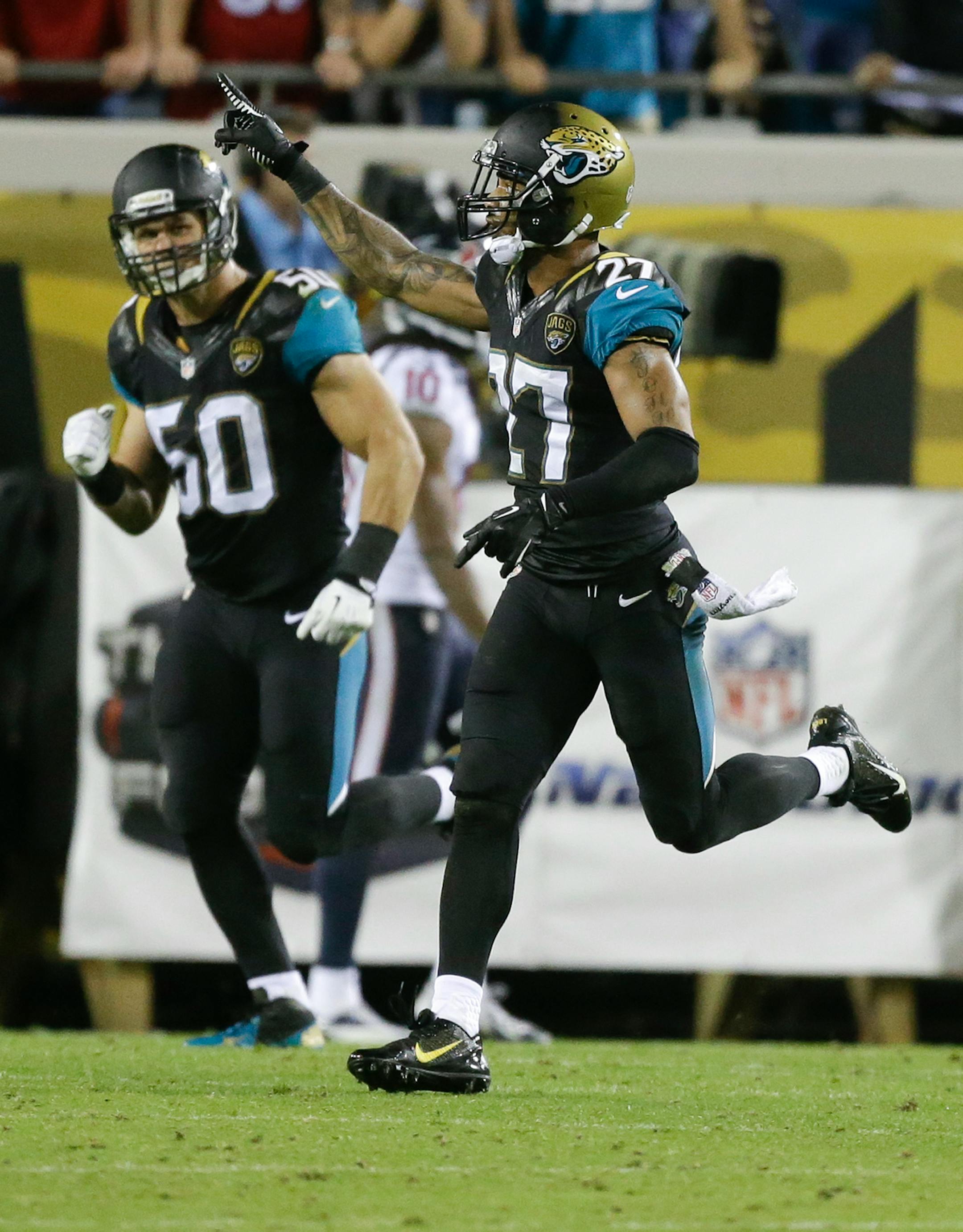 Jacksonville Jaguars cornerback Dwayne Gratz (27) and outside linebacker Russell Allen (50) celebrate after stopping the Houston Texans on a fourth down play during the final minutes of an NFL football game in Jacksonville, Fla., Thursday, Dec. 5, 2013.(AP Photo/John Raoux)