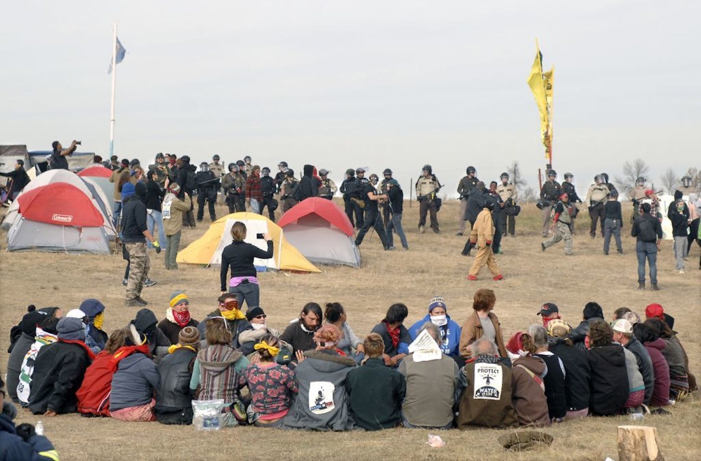 Dakota Access Pipeline protesters sat in a prayer circle at the Front Line Camp as a line of law enforcement officers made their way to remove them and relocate to the overflow camp a few miles to the south on Highway 1806 in Morton County, N.D., Thursday, Oct. 27, 2016.