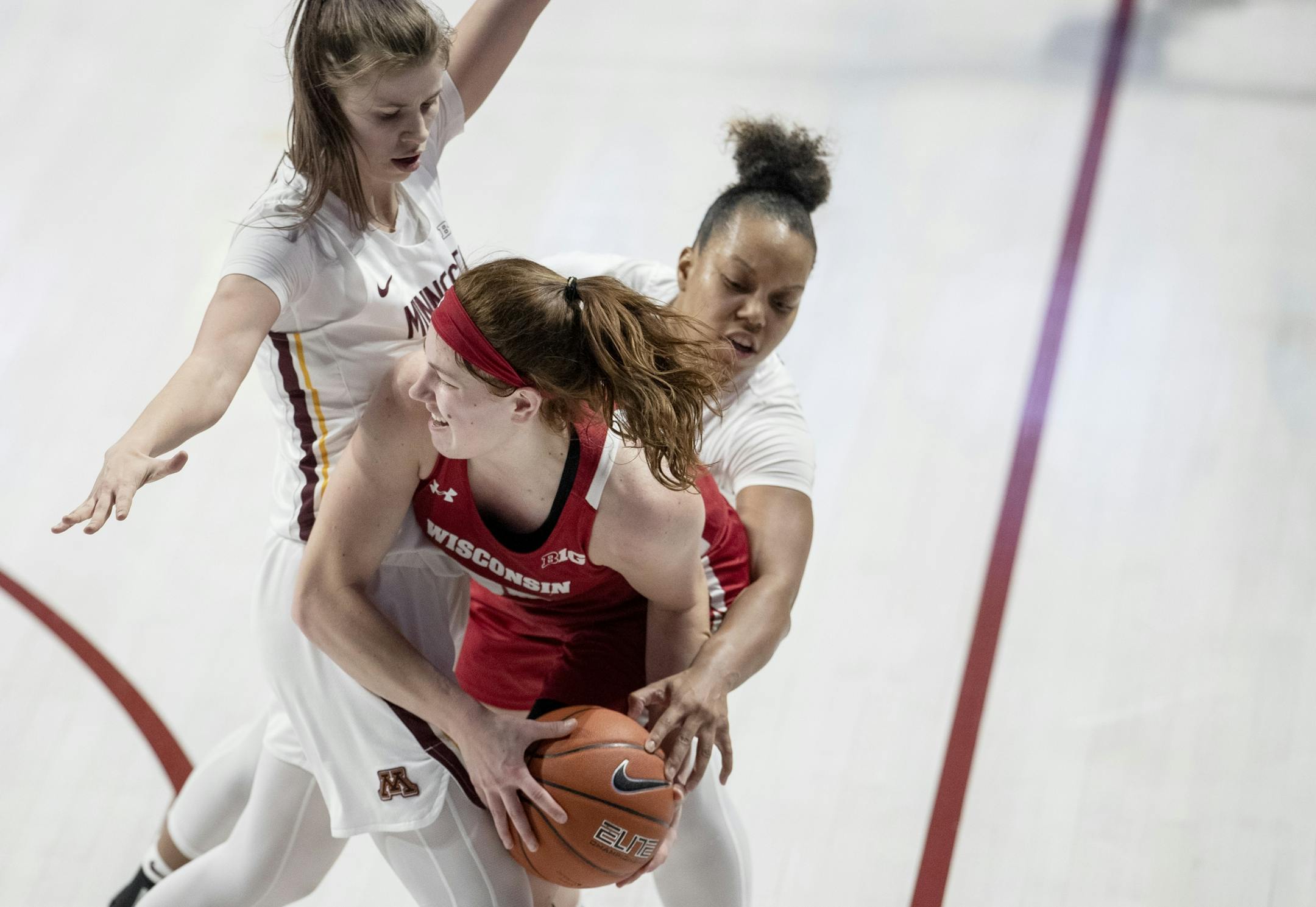 Masha Adashchyk (23) and Gadiva Hubbard (34) defended Kara Crowley (30) of Wisconsin in the fourth quarter.