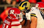 FILE -- Players square off during a college football game between Rutgers and Michigan in Piscataway Township, N.J., Nov. 10, 2018. After a season of 
