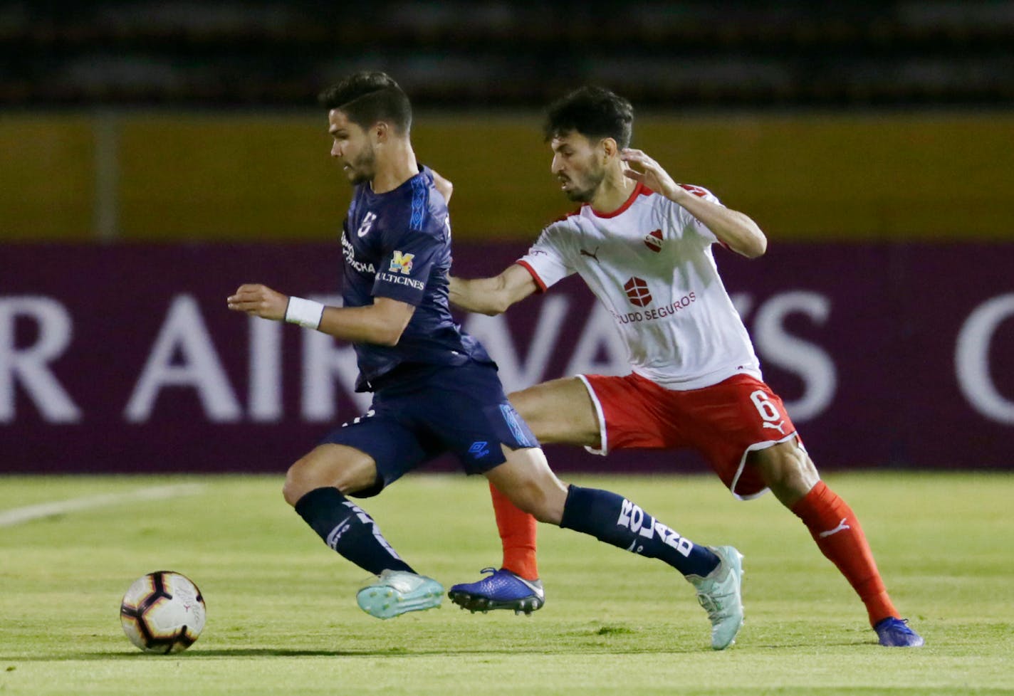 Luis Amarilla of Ecuador's Universidad Catolica, left, fights for the ball with Juan Sanchez Mino of Argentina's Independiente during a Copa Sudamericana match in Quito, Ecuador, Thursday, Aug. 1, 2019. (AP Photo/Dolores Ochoa)