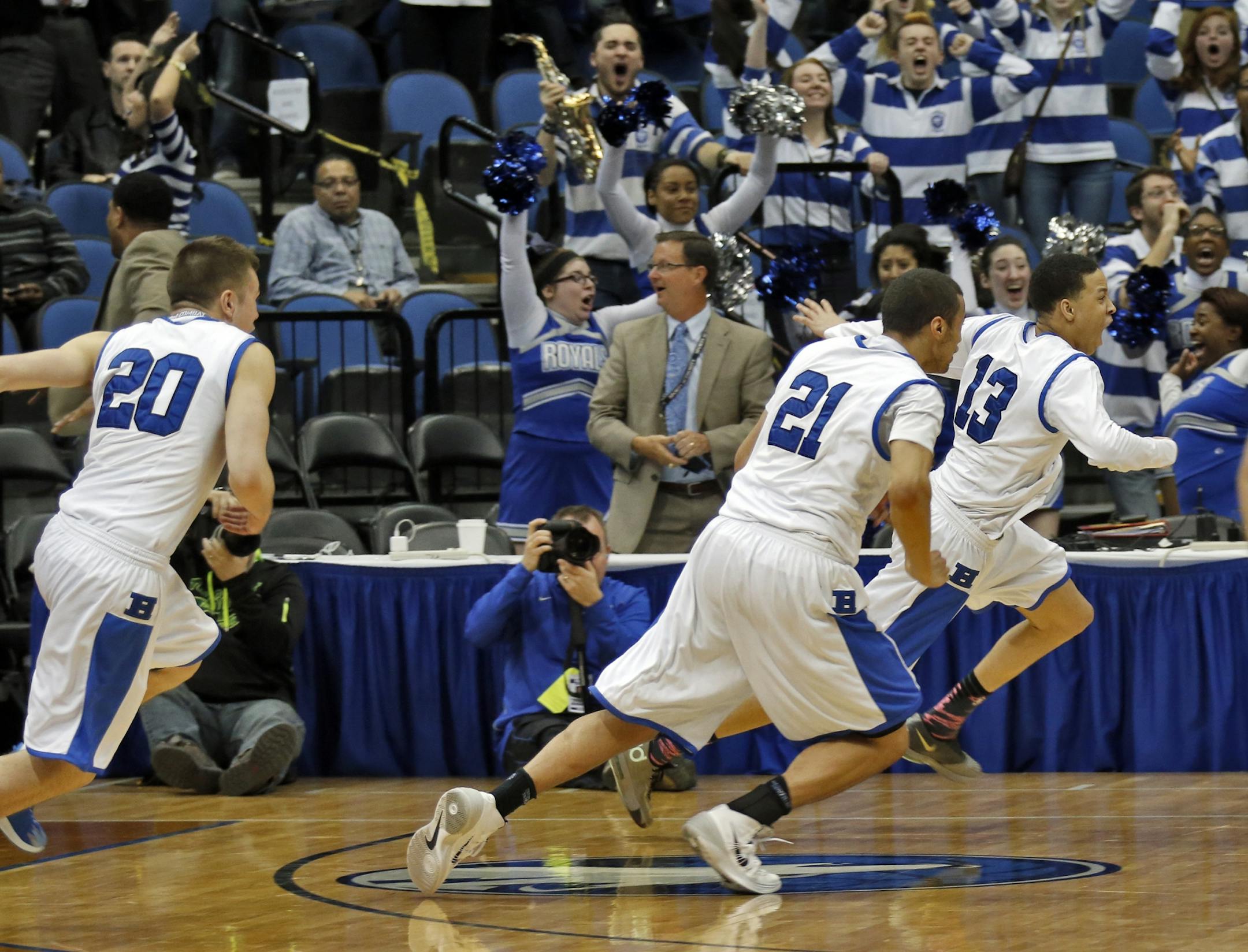 Hopkins Amir Coffey (13) led the victory celebration after hitting a half-court buzzer-beater in four overtimes during the 2014 Class 4A state tournament.