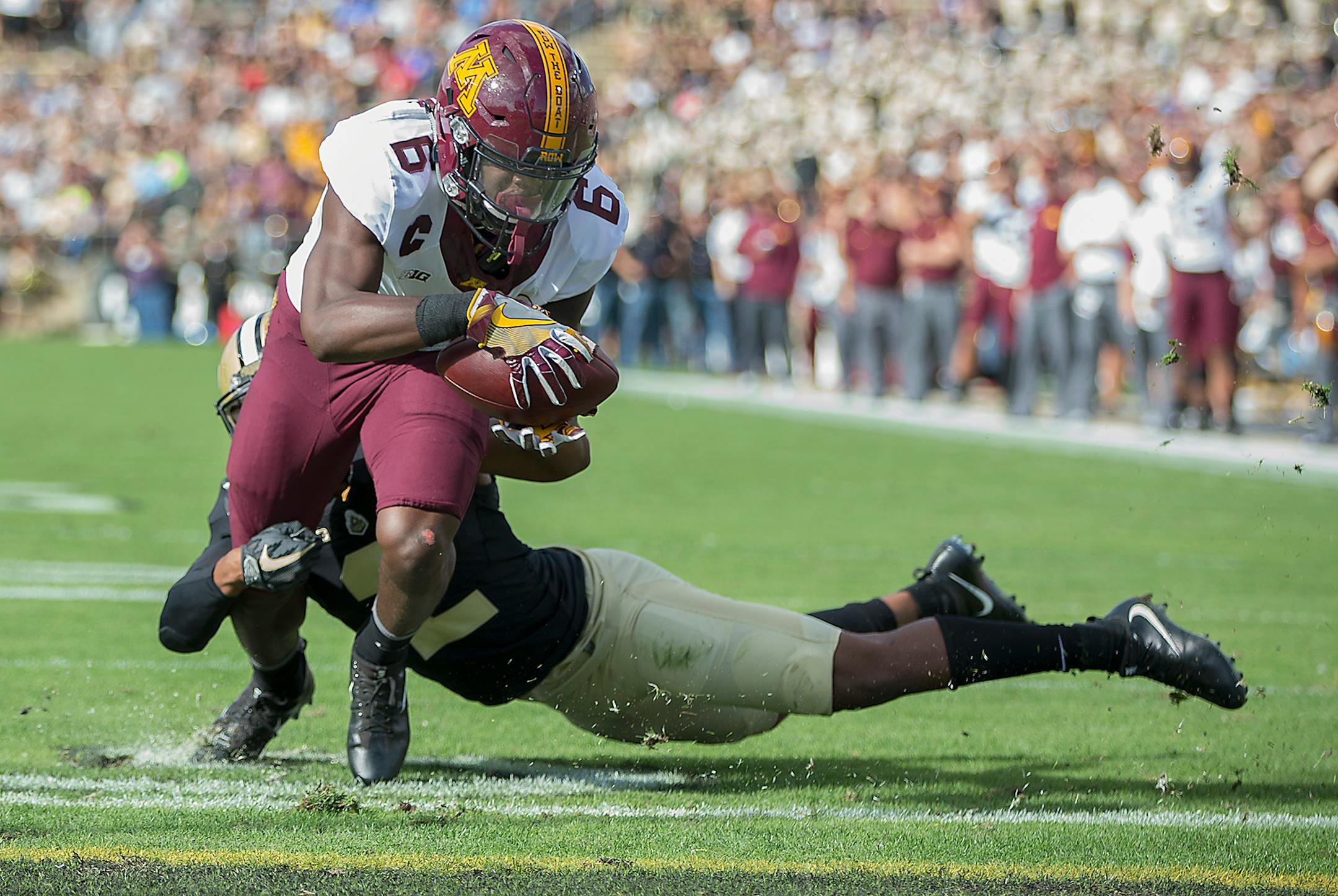 Minnesota wide receiver Tyler Johnson ran the ball into the end zone for a touchdown despite defensive pressure by Purdue cornerback Da'Wan Hunte