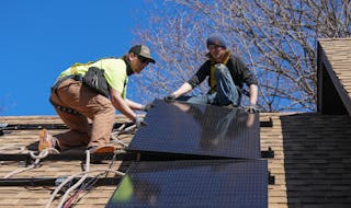 Workers from TruNorth Solar install a rooftop solar panel power system on the roof of Sheila and Richard Miller’s house in Golden Valley.