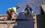 Workers from TruNorth Solar install a rooftop solar panel power system on the roof of Sheila and Richard Miller’s house in Golden Valley.