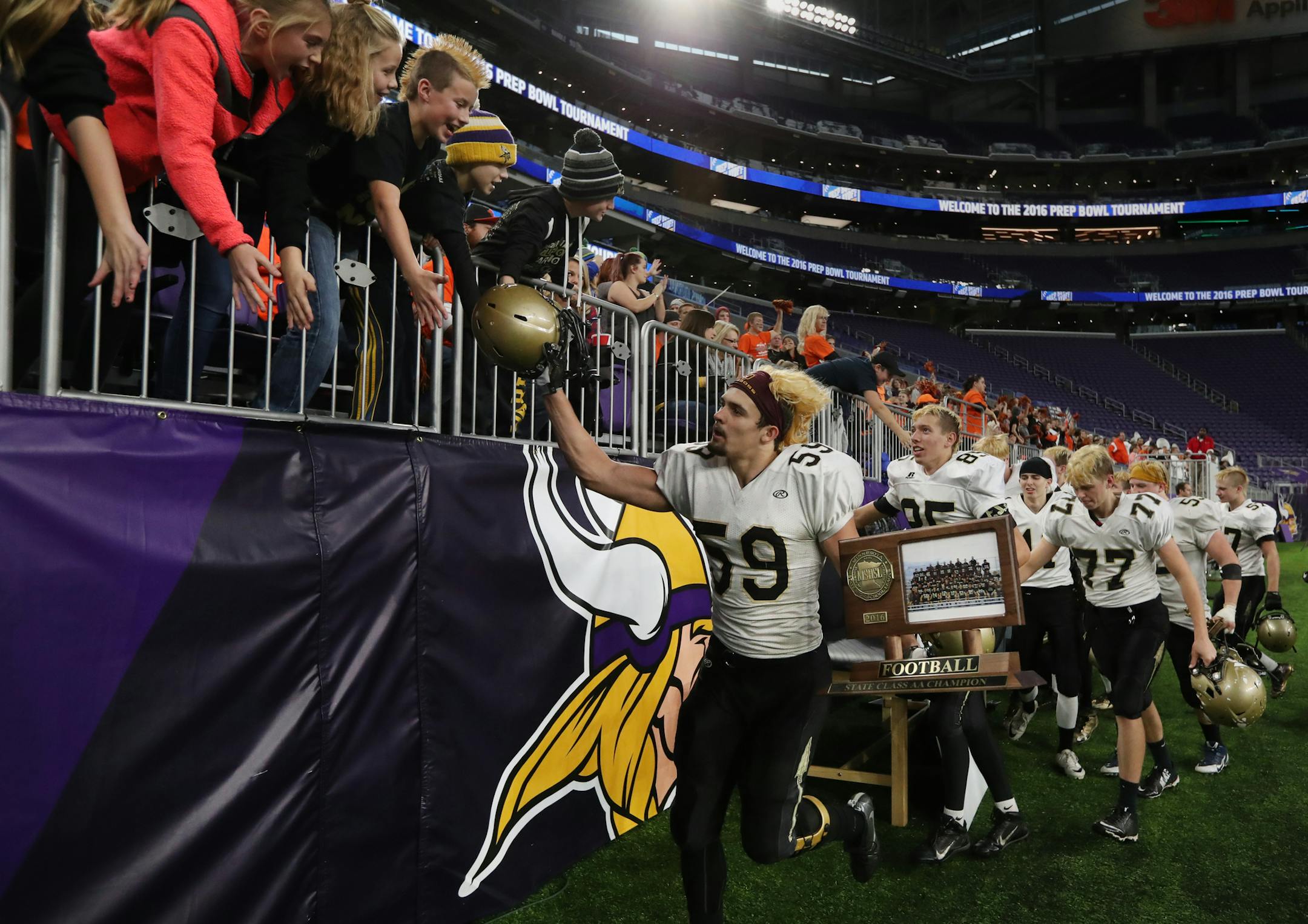 Led by senior defensive end Ezekiel Ott, the Warriors of Caldedonia ran past the stands after their championship win. ] Shari L. Gross / sgross@startribune.com Caledonia defeated Eden Valley-Watkins 61-12 in the 2A football championship at U.S. Bank Stadium in Minneapolis, Minn. on Friday, Nov. 25, 2016.