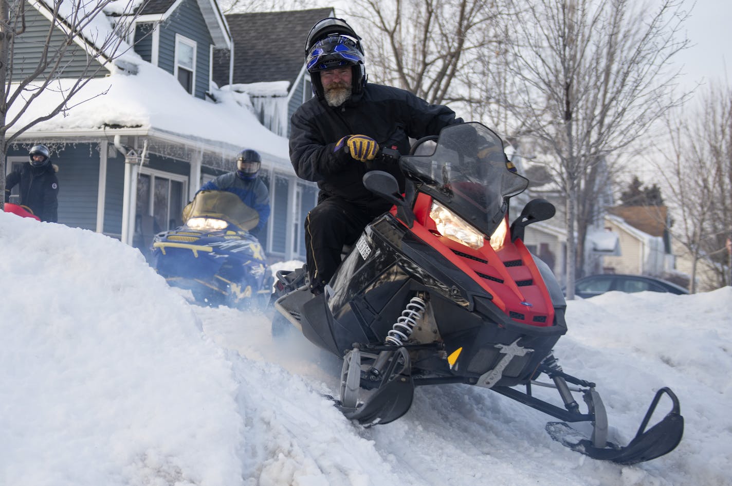 Nick Becchetti drove his snowmobile out of Rob Scheffler's yard. ] COURTNEY DEUTZ &#x2022; courtney.deutz@startribune.com on Friday, March 8, 2019 in Anoka Minnesota. Becchetti and Scheffler ride along the Rum River to downtown Anoka. The city of Anoka created a snowmobile corral for snowmobilers to park at while they spend time downtown Anoka.