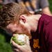 Ethan Logeman digs into a head of lettuce Sunday on the University of Minnesota campus. The University of Minnesota's lettuce club returned after a br