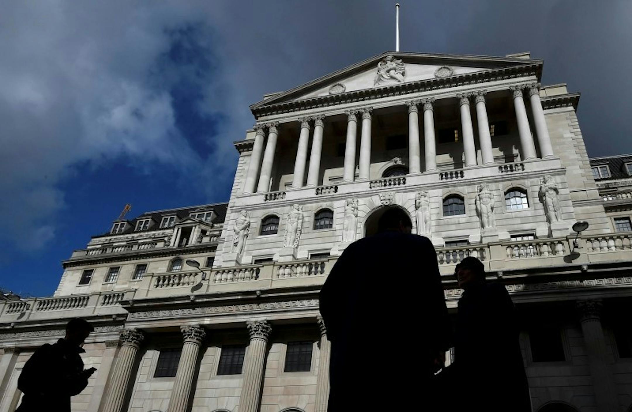 City workers walk past the Bank of England in the City of London, Britain, March 29, 2016. REUTERS/Toby Melville