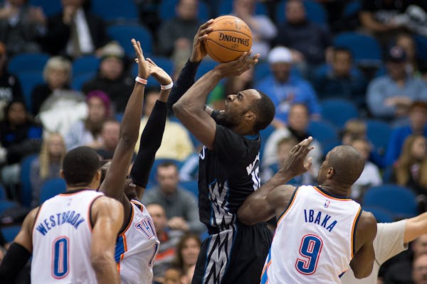 Minnesota Timberwolves forward Shabazz Muhammad (15) attempts a shot but is fouled by Oklahoma City Thunder guard Reggie Jackson (15) during the fourt