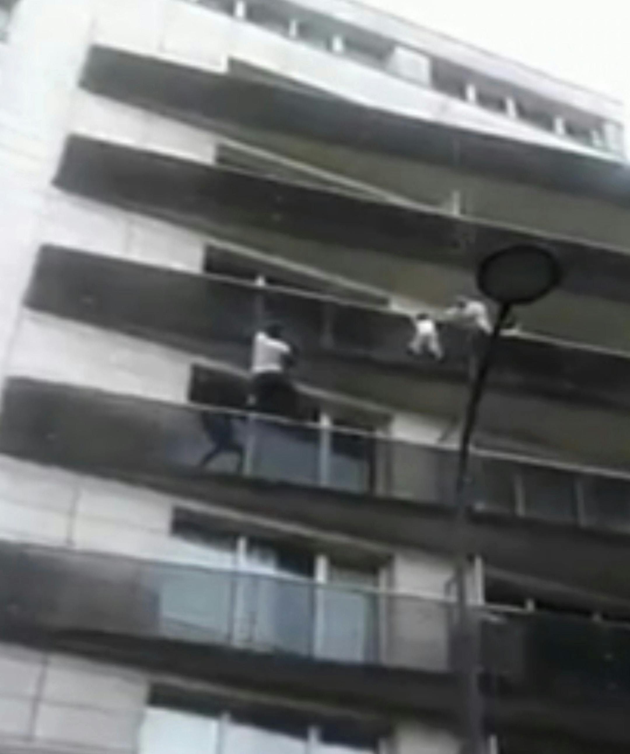 In this Saturday, May 26, 2018 grab taken from UGC video, Mamoudou Gassama scales an apartment building to save a young child dangling from a balcony, in Paris. French President Emmanuel Macron met with Gassama from Mali and lauded him as a hero for saving the young child. Macron said Monday, May 28, 2018 that 22-year-old Mamoudou Gassama would be rewarded for his "exceptional act" with papers to legalize his stay, citizenship if he wants and a job as a firefighter. (AP)