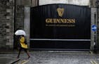 A woman passes the Guinness brewery in Dublin's city centre Wednesday Nov. 11, 2020.