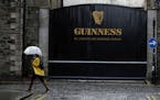 A woman passes the Guinness brewery in Dublin's city centre Wednesday Nov. 11, 2020.