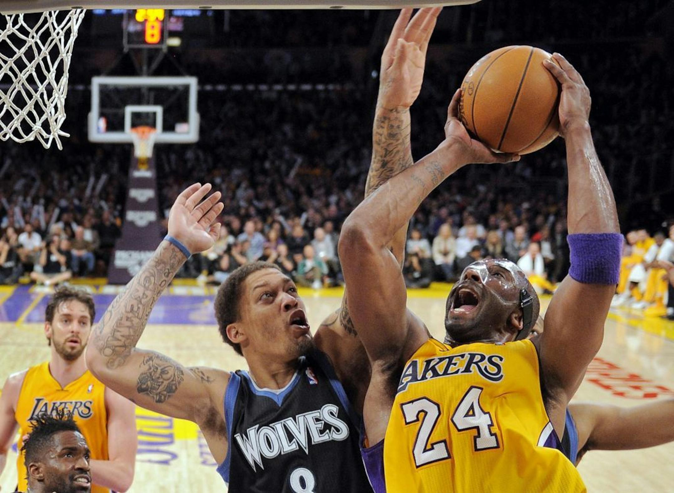 Los Angeles' Kobe Bryant, right, puts up a shot against Minnesota's Michael Beasley.