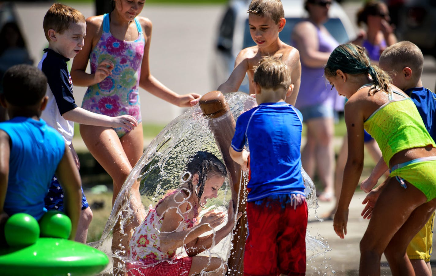 Kids play in the new splash pad at Cliff Fen Park in Burnsville, MN. Water from the park is not reused but drains into the nearby fen. Water flows rotate through only a few of the pad's features an any time and the system automatically shuts off every few minutes requiring a user to step on a foot switch to restart it. ] GLEN STUBBE * gstubbe@startribune.com Tuesday, August 4, 2015