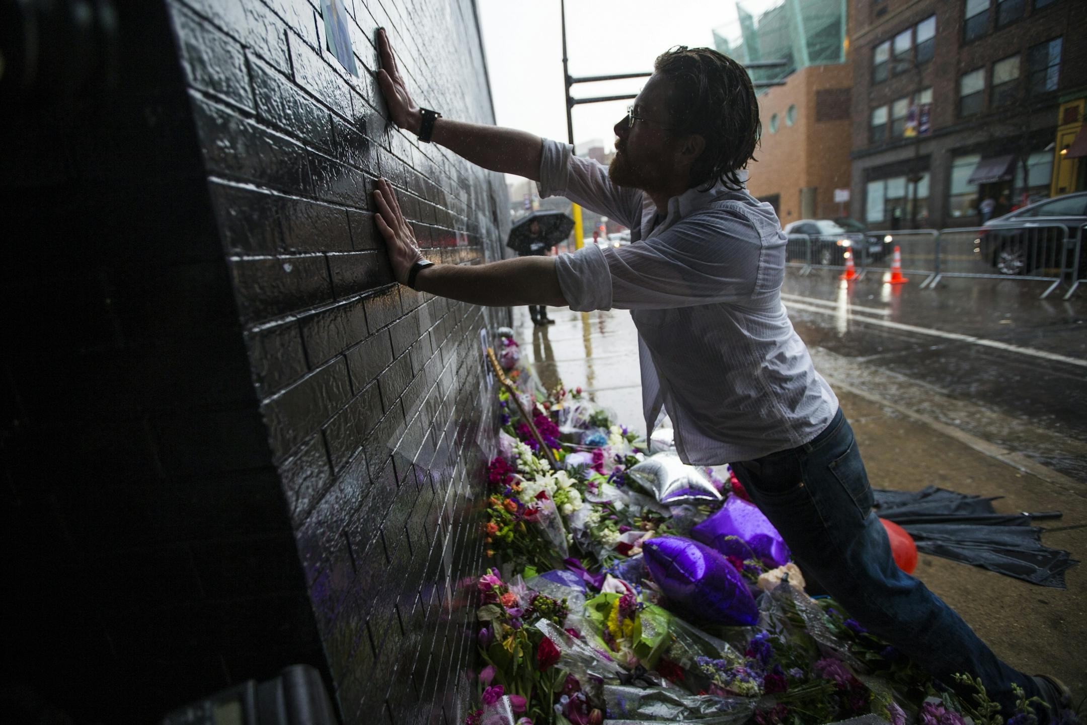 Brendan Jones got soaked in the rain as he paid tribute to Prince at his star at First Avenue on Thursday, April 21, 2016. Prince was found dead at his home today at the age of 57.
