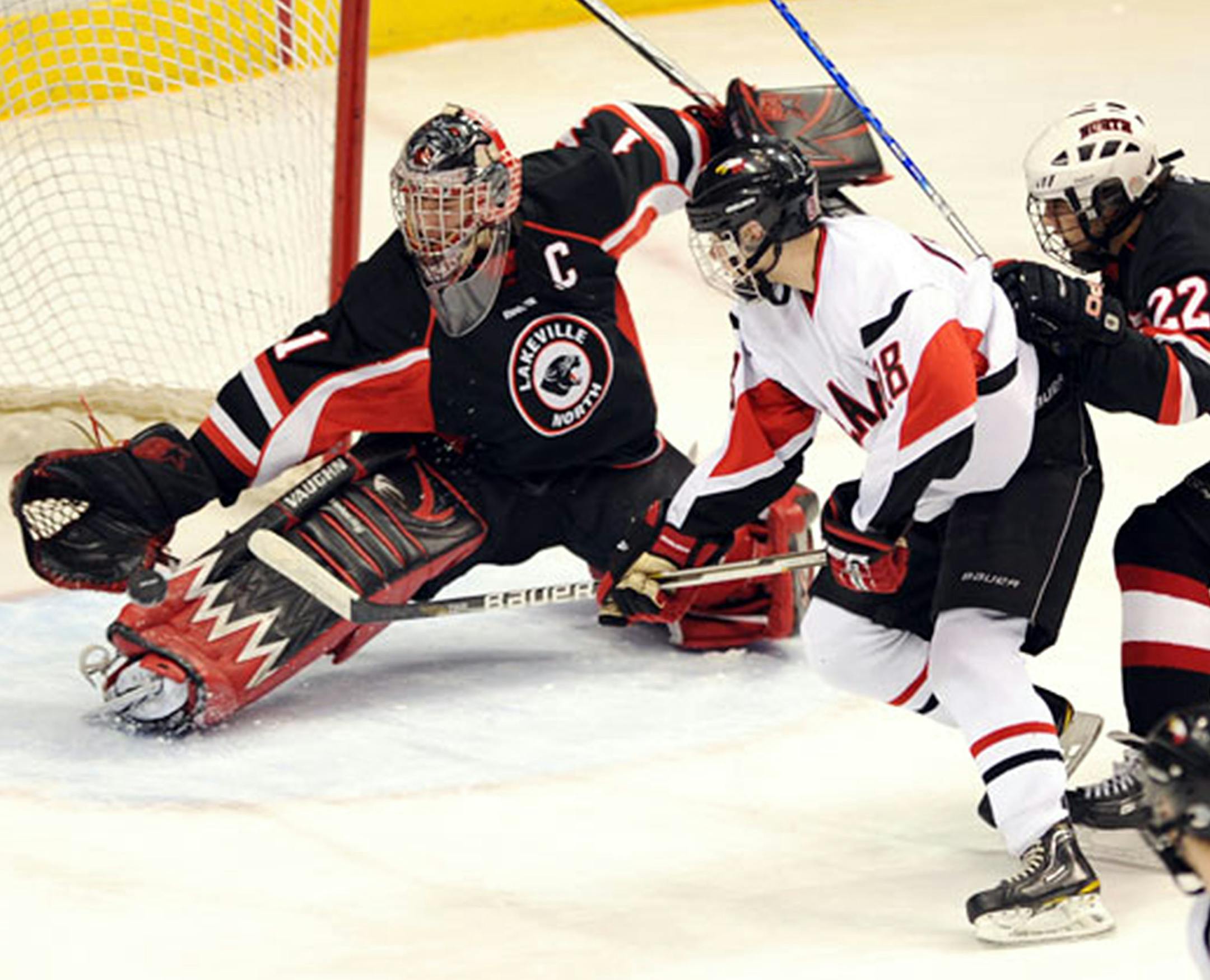 Lakeville North goalie Charlie Lindgren gets his glove on the puck during a Class 2A quarterfinal matchup. (Photo by Helen Nelson)