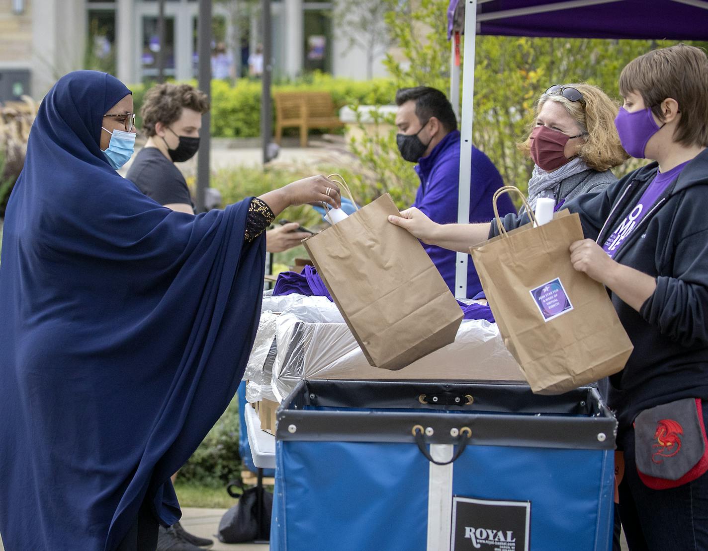 St. Thomas employees, from far left, Jeff Holstein, Linda Baughman and Erica Berglund handed out masks, thermometers and T-shirts on Monday, Sept. 7.