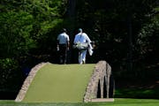 Tiger Woods walks over the Ben Hogan Bridge on the 12th hole during third round at the Masters on Saturday.