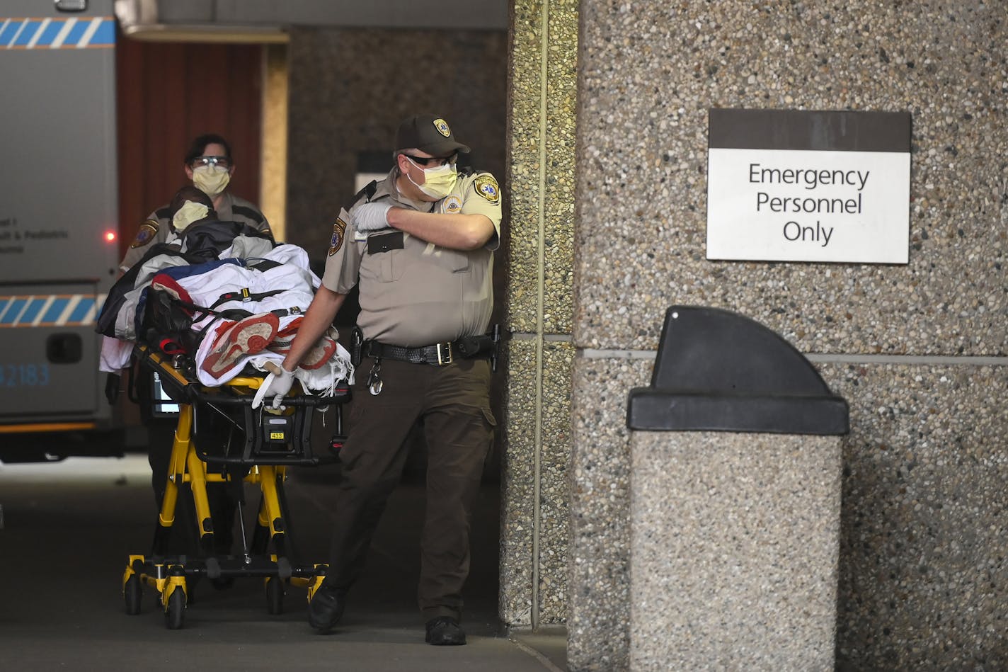 Emergency medical personnel wear personal protective equipment while they transport a patient into Hennepin County Medical Center on in April 2020 in Minneapolis.