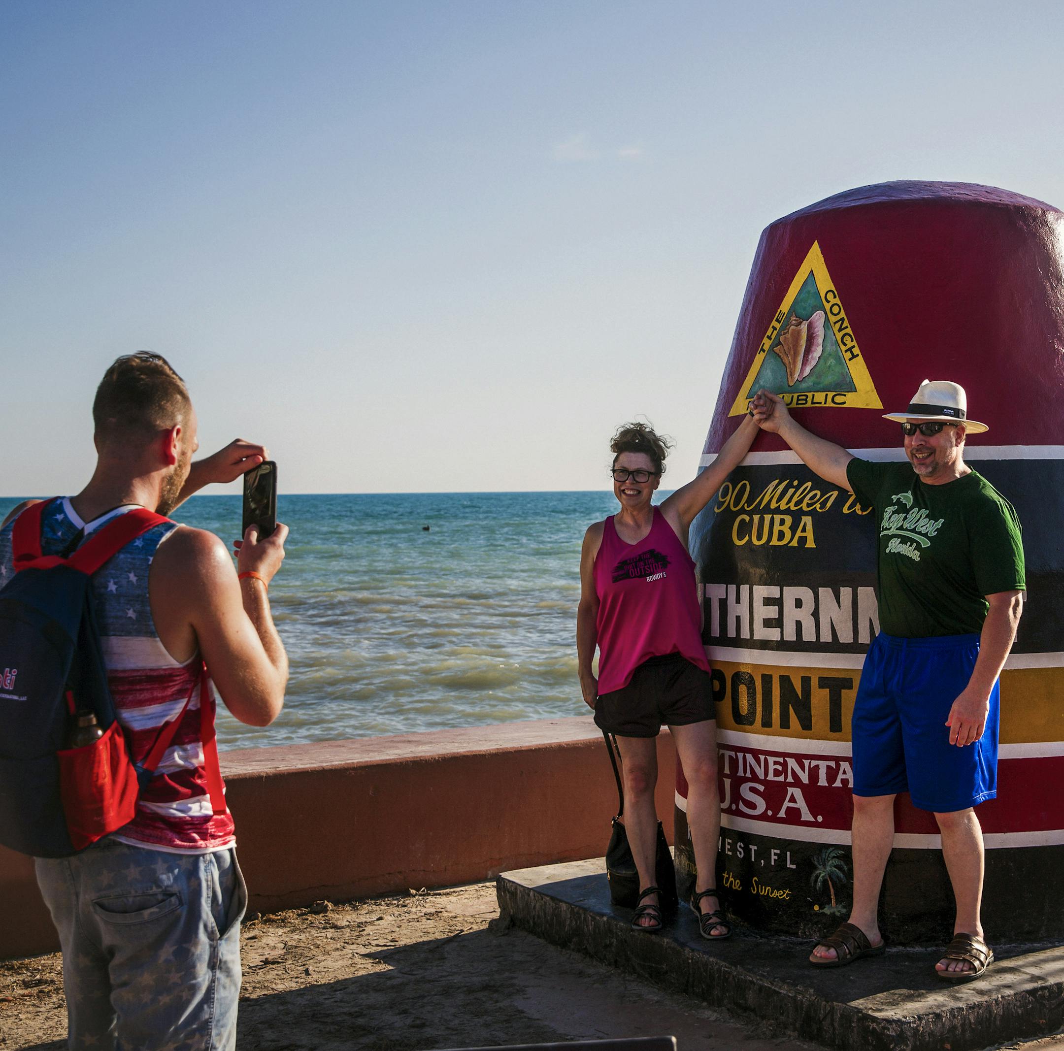 Tourists pose for photos at the Southernmost Point in Key West, Fla., Dec. 3, 2018. The string of coral islands that arc from the Florida peninsula south toward Havana has a long history of attracting pirates, profiteers and seekers of a Caribbean lifestyle within the United States. (Scott McIntyre/The New York Times)