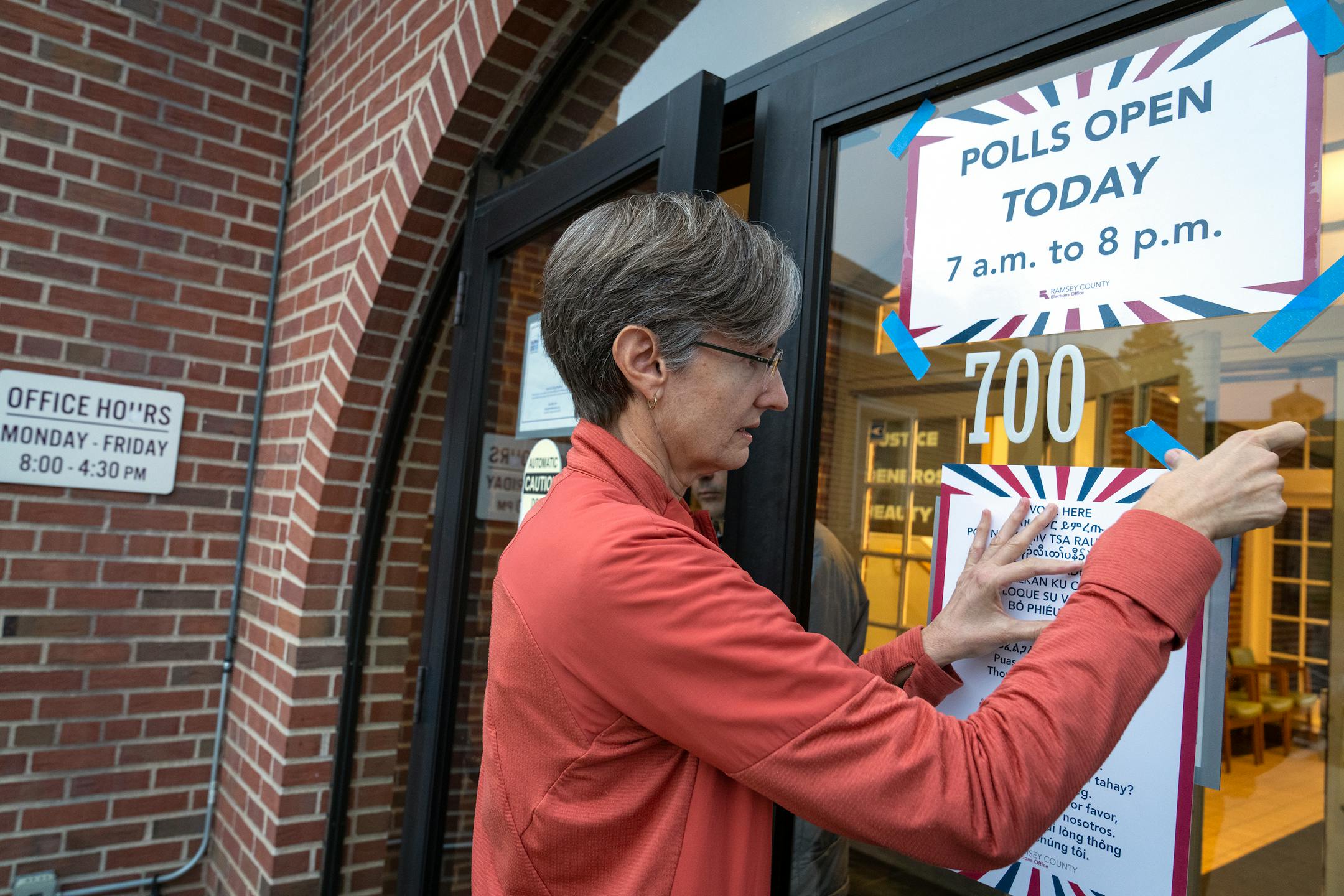 Volunteer Nancy Johnson puts up signs outside Gloria Dei Lutheran Church in Ward 3 of St. Paul.