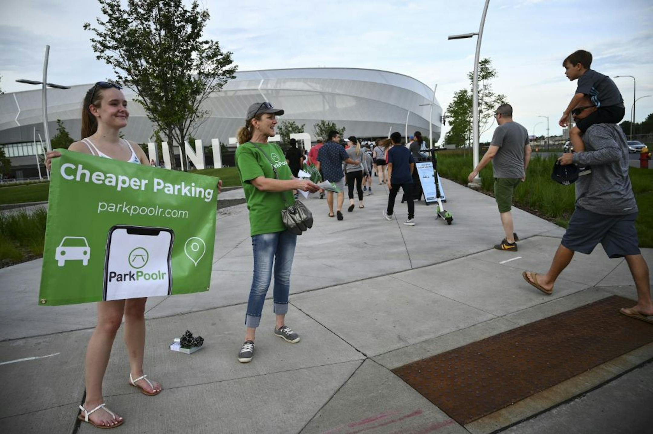 From left, Emma and her mother Jan Lefebvre, advertised for their company, ParkPoolr, outside Allianz Field Wednesday night. The company was founded by Emma's brother, Jack Lefebvre, an entrepreneurship student at the University of Minnesota, and uses an app to sell available parking spots outside nearby residents' homes.