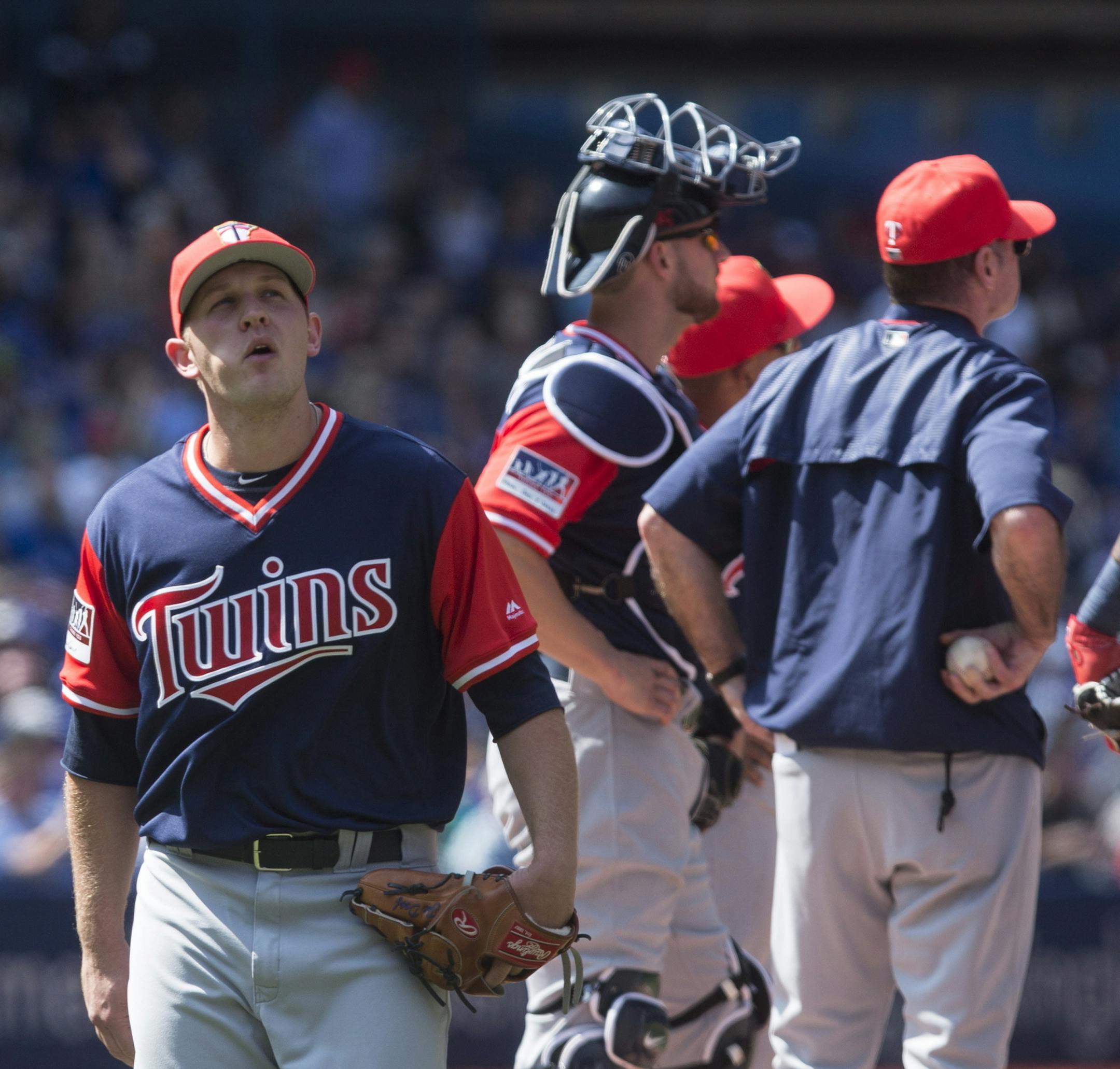 Minnesota Twins relief pitcher Tyler Duffey, left, reacts as he is pulled from a baseball game after recording only one out against the Toronto Blue Jays during fifth inning in Toronto, Saturday, Aug. 26, 2017. (Chris Young/The Canadian Press via AP)