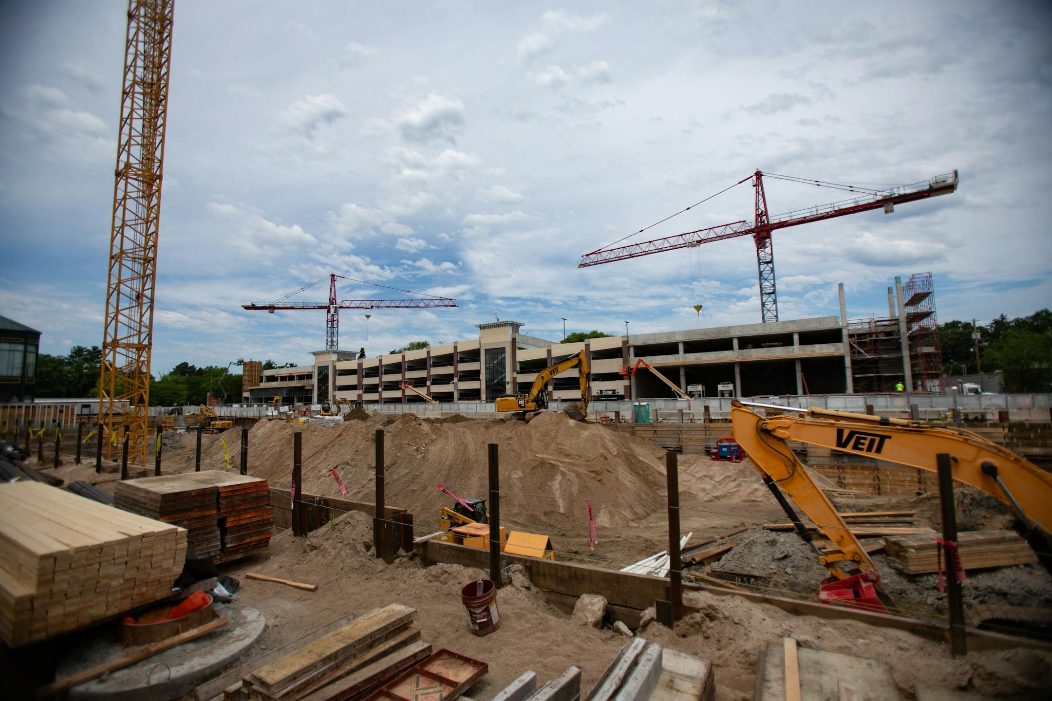 The construction site sits directly behind a street full of small shops and restaurants.