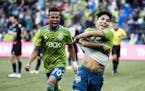 Seattle Sounders forwards Handwalla Bwana, left, and Raul Ruidiaz celebrate Ruidiaz' second goal during an MLS soccer match against the San Jose Earth