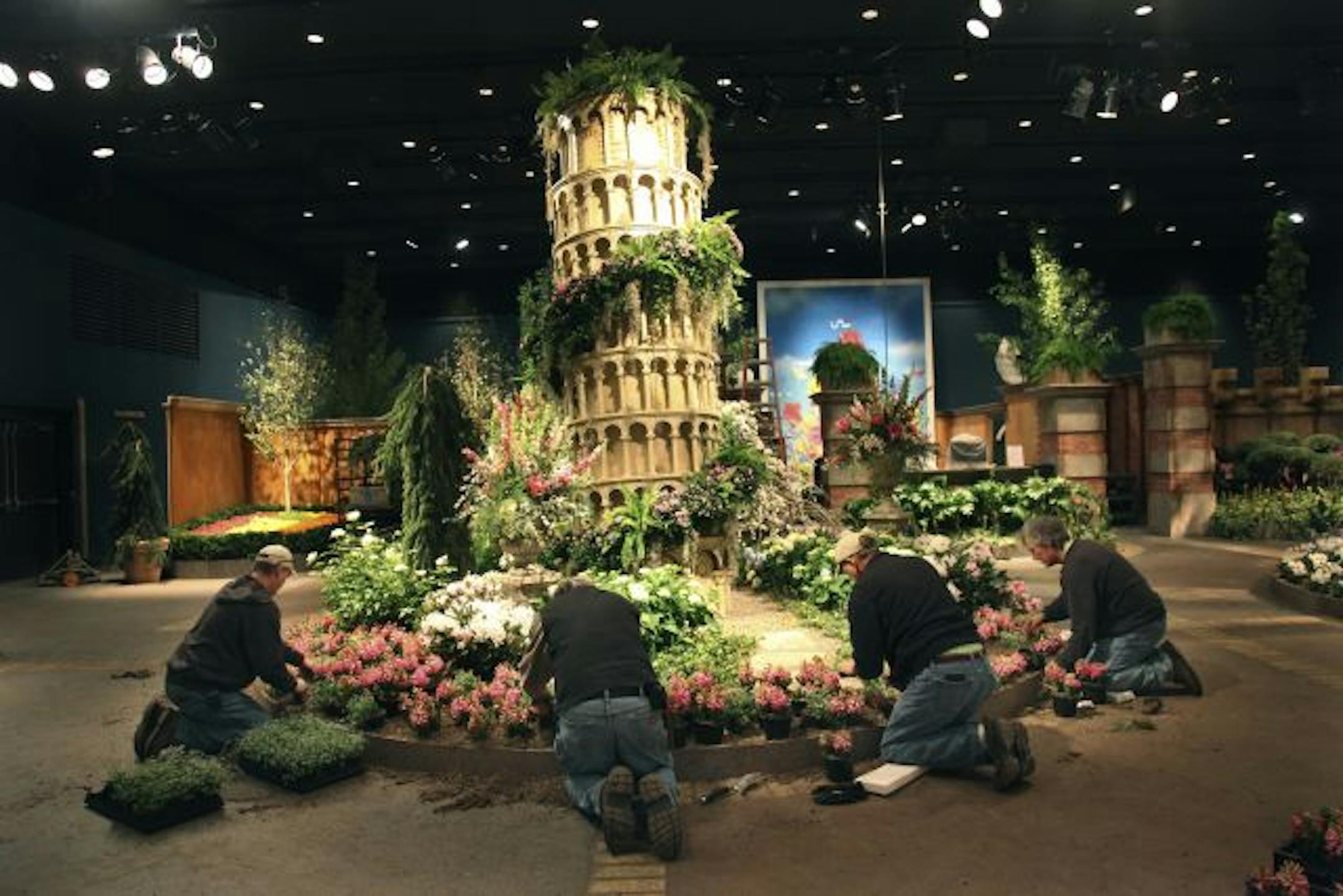 From left, Jim Hoiosen, Juan Valtierra, Steve Hutton and Tim Havener plant hyacinths near the Leaning Tower of Pisa representation at the Macy's Flower Show.