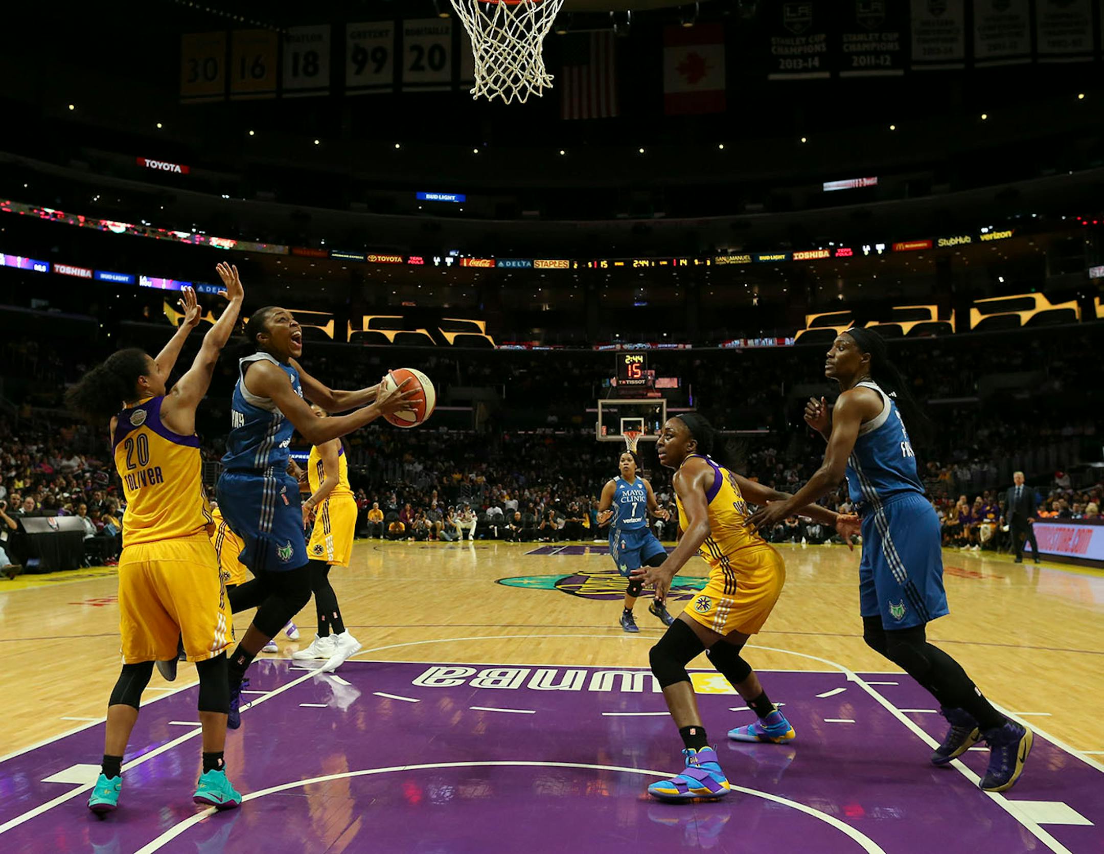 Minnesota Lynx guard Renee Montgomery (21) shot under the defense of Los Angeles Sparks guard Kristi Toliver (20) in the first quarter.