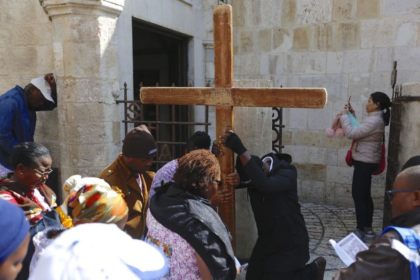 Christian worshipers pray along the Via Dolorosa near the Church of the Holy Sepulchre, traditionally believed by many to be the site of the crucifixion of Jesus Christ, during the Good Friday procession in Jerusalem's old city, Friday, April 19, 2019.