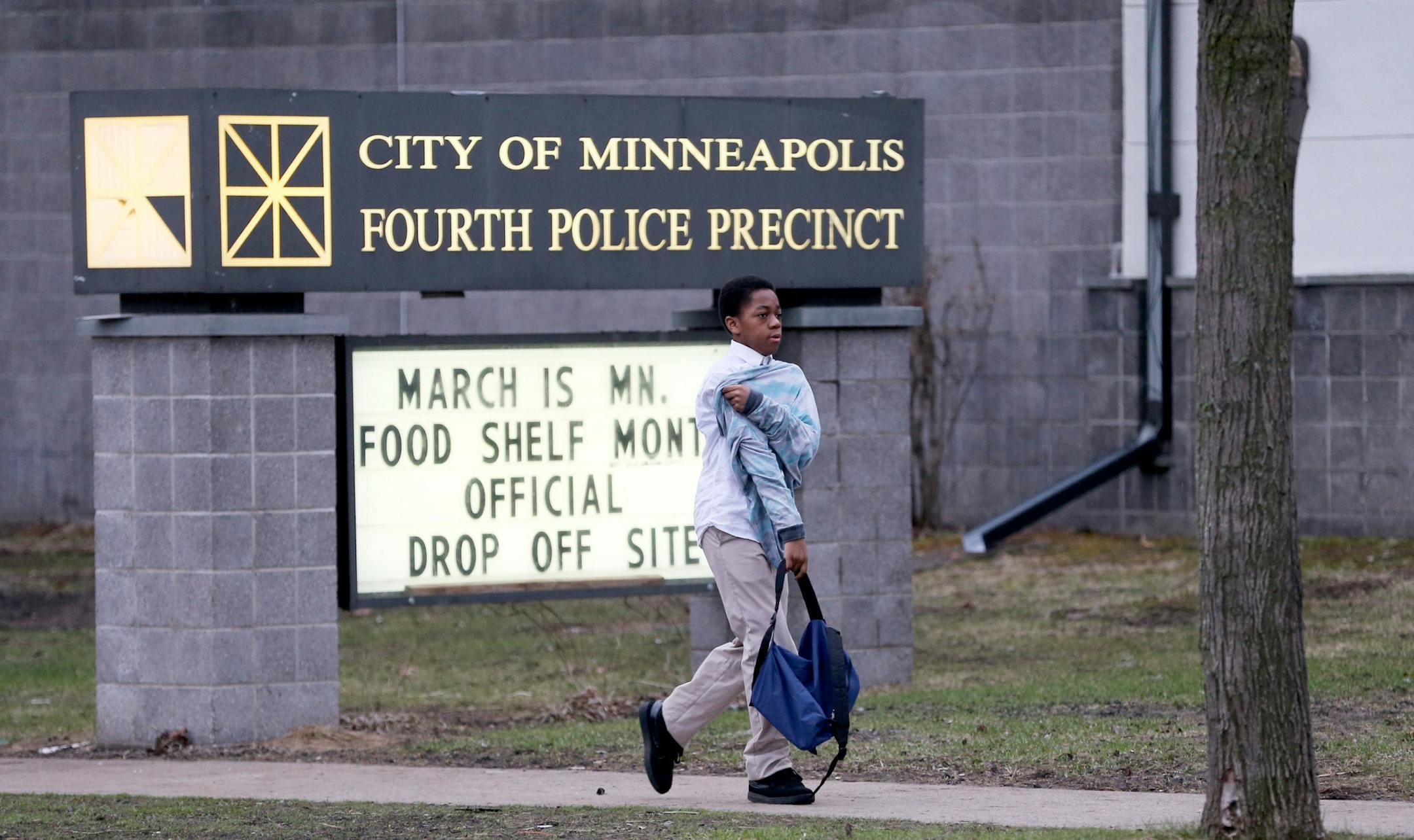 A day after Hennepin County DA Mike Freeman decided not to charge two police officers in the shooting of Jamar Clark in November, a young boy walks by the 4th police precinct around dawn Thursday, March 31, 2016, in Minneapolis, MN.](DAVID JOLES/STARTRIBUNE)djoles@startribune.com The day after coverage of the decision not to charge police officers in the shooting of Jamar Clark.