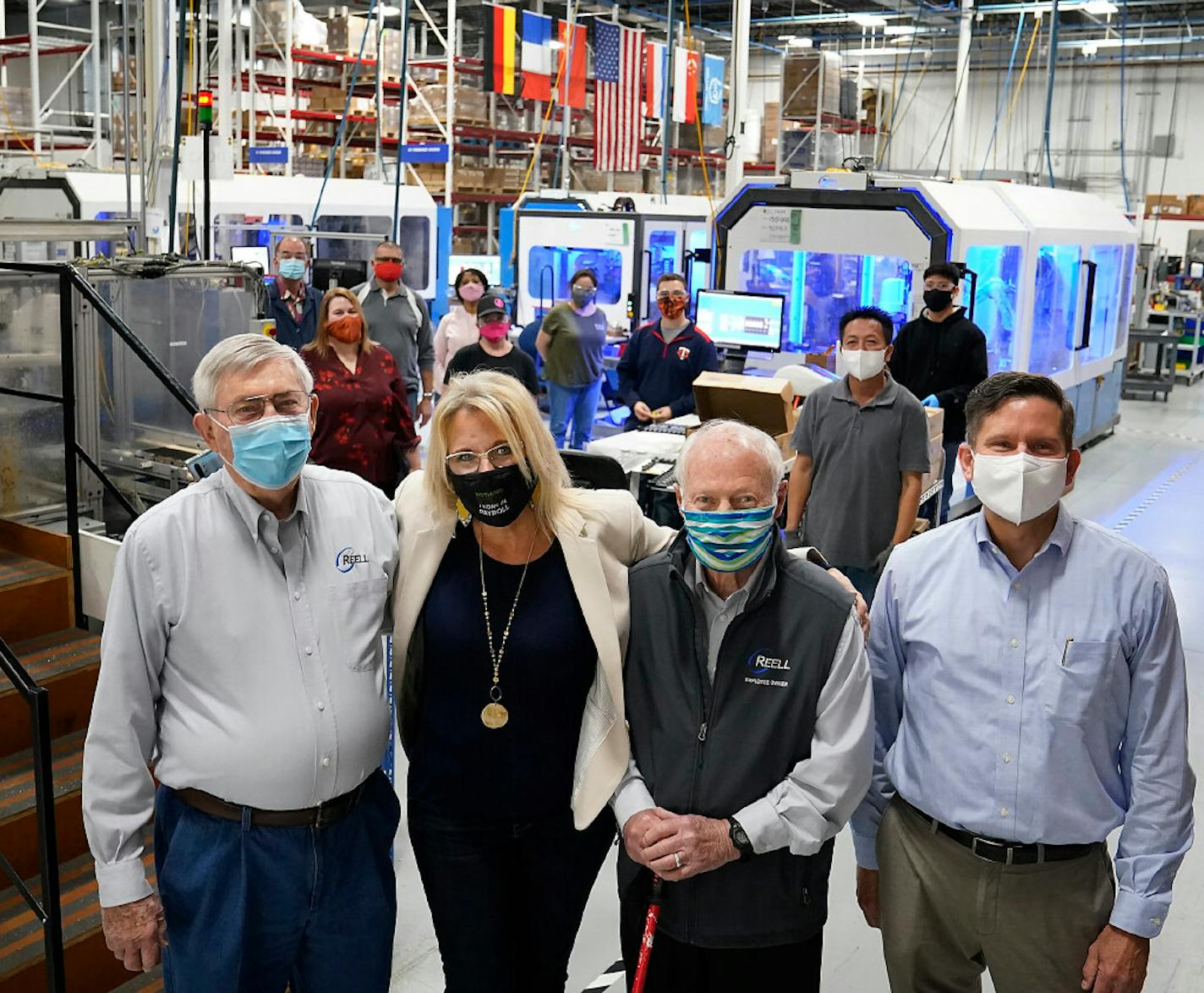 From left, Reell Precision Manufacturing founder Bob Wahlstedt, VP of Global Human Resources Shari Erdman, founder Lee Johnson and CEO Kyle Smith with employee-owners on the manufacturing floor where Reell makes components for global automotive, medical and other industries from Vadnais Heights.