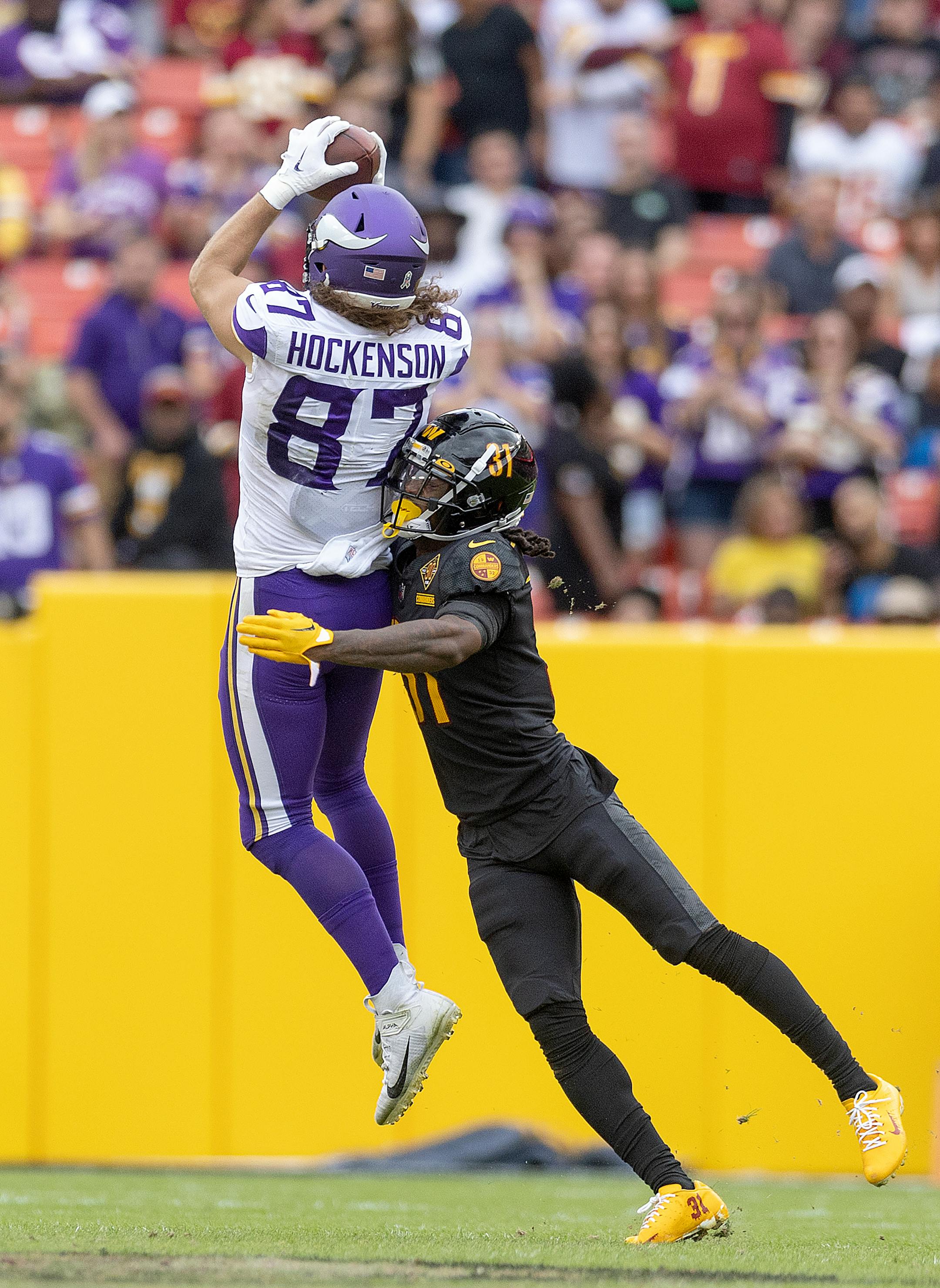 Minnesota Vikings tight end T.J. Hockenson (87) makes a grab as he's defended by Washington Commanders safety Kamren Curl (31) in the second quarter.