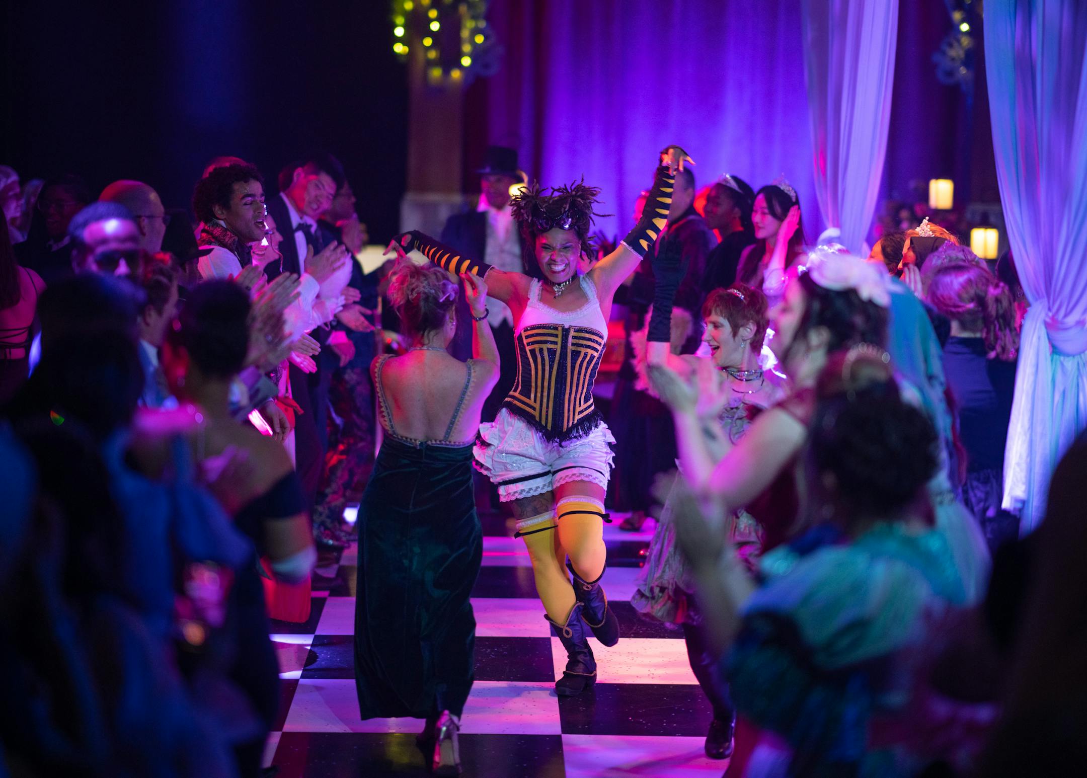 A company member, center, danced along a gauntlet of guests with two audience members on opening night of The Queen's Ball: A Bridgerton Experience.