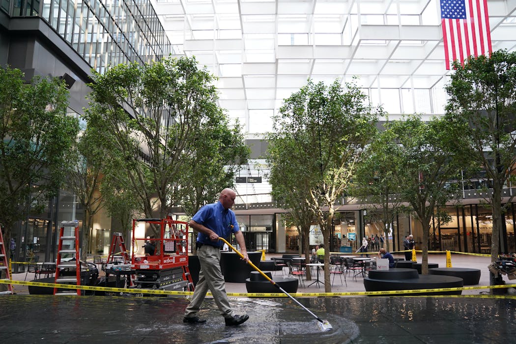 IDS Building Superintendent Jeff Grubb used a squeegee to clean the new infinity pool Tuesday at the newly remodeled Crystal Court.