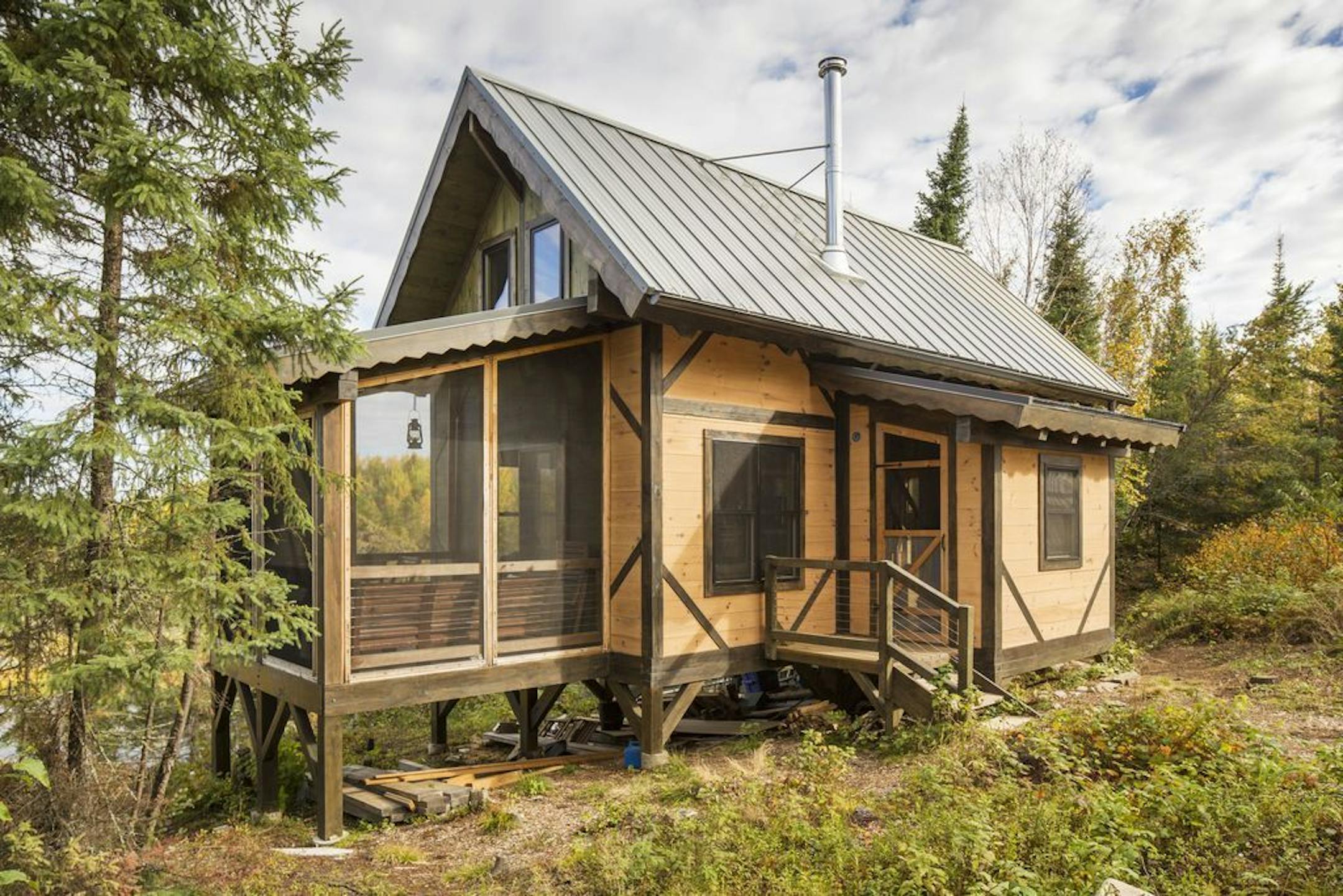 The off-the-grid rustic retreat uses lantern light, wood stove heat, and water hand-pumped from a well, on the edge of the BWCA, by Dale Mulfinger, SALA Architects.