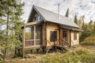 The off-the-grid rustic retreat uses lantern light, wood stove heat, and water hand-pumped from a well, on the edge of the BWCA, by Dale Mulfinger, SA